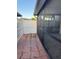 Cozy outdoor patio space with brick pavers, screened enclosure, and privacy fence for relaxing or entertaining at 7601 W Deleon Ct, Tampa, FL 33615