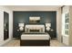 Cozy bedroom featuring a plush bed, decorative lamps, a large window, and an accent wall at 7754 Painted Sky Pl, Land O Lakes, FL 34637