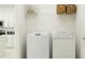 Convenient laundry room with a washing machine, dryer, and shelving for storing supplies at 7754 Painted Sky Pl, Land O Lakes, FL 34637