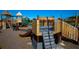 Community playground featuring wooden play structures with slides, a climbing area, and shaded features at 7754 Painted Sky Pl, Land O Lakes, FL 34637