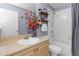 Bathroom with a single sink vanity, decorative shelves, and a shower-tub combination at 8007 Bally Money Rd, Tampa, FL 33610