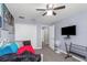 Bedroom features a ceiling fan, closet, tv, and view into the home's hallway at 8007 Bally Money Rd, Tampa, FL 33610