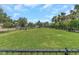 Large, fenced dog park with well-maintained grass and mature trees at 8007 Bally Money Rd, Tampa, FL 33610
