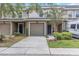 Charming townhome with an attached garage, a neutral exterior, and a neatly kept lawn at 8007 Bally Money Rd, Tampa, FL 33610