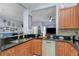Stylish kitchen with stainless steel appliances, dark countertops, wooden cabinetry, and an open layout at 8007 Bally Money Rd, Tampa, FL 33610