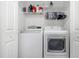Laundry room with a full sized washer and dryer and storage shelves at 8007 Bally Money Rd, Tampa, FL 33610