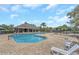 Community pool with lounge chairs, a covered seating area, and an inviting, bright-blue swimming pool at 8007 Bally Money Rd, Tampa, FL 33610