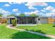 Well-maintained backyard featuring a manicured lawn, a screened lanai, and a neat walkway at 8314 Stillbrook Ave, Tampa, FL 33615
