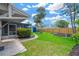 Spacious backyard with lush green grass, landscaping, mature palm trees, and a shed at 8314 Stillbrook Ave, Tampa, FL 33615