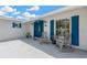 Charming front porch with rocking chairs and a striking blue door at 8314 Stillbrook Ave, Tampa, FL 33615
