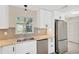 Well-lit kitchen with stainless steel dishwasher and refrigerator, granite counters, and updated backsplash at 8314 Stillbrook Ave, Tampa, FL 33615