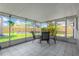 Enclosed patio with tiled floor and backyard view with a table and chairs, great for outdoor dining at 8314 Stillbrook Ave, Tampa, FL 33615