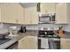 Kitchen with stainless steel appliances and cream cabinetry offer a modern aesthetic at 842 Tennyson Mill Cir, Tampa, FL 33619