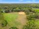 Aerial view showcasing a sprawling green field with a baseball diamond and surrounding trees at 9084 Quail Creek Dr, Tampa, FL 33647