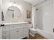 Bright bathroom with stylish vanity, round mirror, and a shower over a tub at 9084 Quail Creek Dr, Tampa, FL 33647
