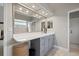 Bathroom with large mirror, white countertop, gray cabinets, and views into the shower area and closet at 9084 Quail Creek Dr, Tampa, FL 33647