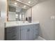 Well-lit bathroom with gray vanity, white countertop, and modern faucet under a large mirror at 9084 Quail Creek Dr, Tampa, FL 33647