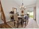 Cozy dining room with decorative chandelier, wooden table set, and sliding door access to outdoor area at 9084 Quail Creek Dr, Tampa, FL 33647