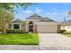 Charming single-Gathering home featuring a manicured lawn, brick accents, and a two-car garage at 9084 Quail Creek Dr, Tampa, FL 33647