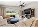 Spacious living room with comfy sectional, modern ceiling fan, and a clear view of the outdoor pool at 9084 Quail Creek Dr, Tampa, FL 33647