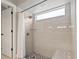 Tiled shower featuring a rainfall shower head, seating, and a large window for natural light at 9084 Quail Creek Dr, Tampa, FL 33647
