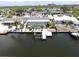 Aerial view of waterfront home with screened pool, dock, boat lift, and manicured landscaping at 916 Sago Palm Way, Apollo Beach, FL 33572