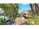 Landscaped backyard with a brick walkway, lush tropical greenery, and seating area at 916 Sago Palm Way, Apollo Beach, FL 33572