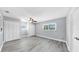 Well-lit bedroom with ceiling fan, light gray wood floors, large window, and spacious closets at 916 Sago Palm Way, Apollo Beach, FL 33572