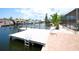 Exterior view of a private dock on a waterfront property with brick pavers and tropical foliage at 916 Sago Palm Way, Apollo Beach, FL 33572