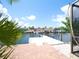 View of the dock over the canal water, and adjacent brick patio at 916 Sago Palm Way, Apollo Beach, FL 33572