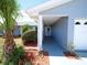 Covered front porch with view of the home's manicured landscaping at 916 Sago Palm Way, Apollo Beach, FL 33572