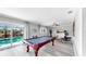 Bright game room with a pool table and large glass doors to the pool area at 916 Sago Palm Way, Apollo Beach, FL 33572