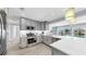 Bright kitchen boasts stainless appliances, gray cabinets, and a view of the pool at 916 Sago Palm Way, Apollo Beach, FL 33572