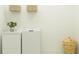 Bright laundry room with modern appliances and storage, accented by decorative baskets and a small plant at 9545 Minnow Ray Dr, Land O Lakes, FL 34638