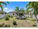 Spacious backyard with an outdoor seating area under a pergola and tropical landscaping at 9931 Victory Gallop Loop, Ruskin, FL 33573