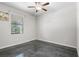 Cozy bedroom featuring a ceiling fan, window, and polished concrete floor at 9931 Victory Gallop Loop, Ruskin, FL 33573