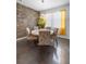 Dining area featuring unique stone accent wall, modern lighting, and large bright windows at 9931 Victory Gallop Loop, Ruskin, FL 33573