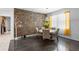 Dining area featuring unique stone accent wall, modern lighting, and large bright windows at 9931 Victory Gallop Loop, Ruskin, FL 33573