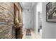 Elegant hallway with a stone accent wall, console table and decorative mirror at 9931 Victory Gallop Loop, Ruskin, FL 33573
