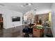 Open concept space featuring decorative trees, furniture, stone accent wall, and kitchen bar beyond at 9931 Victory Gallop Loop, Ruskin, FL 33573