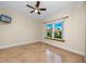 Bright bedroom features a ceiling fan, flat screen tv, and a sun-filled window with neighborhood views at 10764 70Th Ave # 5302, Seminole, FL 33772