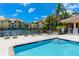 Relaxing pool area featuring lounge chairs, tables, and a community tennis court nearby at 10764 70Th Ave # 5302, Seminole, FL 33772