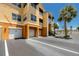 Exterior view of condo garages and adjacent parking, with stairway access to upper levels at 10764 70Th Ave # 5302, Seminole, FL 33772