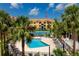 Resort-style condo complex featuring a sparkling pool, tennis court, palm trees and tropical landscaping at 10764 70Th Ave # 5302, Seminole, FL 33772