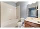 Bathroom has a shower-tub combo, a wooden vanity and neutral colors at 11006 Tahiti Isle Ln, Tampa, FL 33647