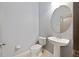 Powder room featuring pedestal sink and round mirror at 11006 Tahiti Isle Ln, Tampa, FL 33647