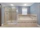 Bathroom featuring separate shower and soaking tub with decorative tile accents at 11006 Tahiti Isle Ln, Tampa, FL 33647