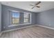 Bedroom with a ceiling fan, wood-look floors and large windows letting in natural light at 11006 Tahiti Isle Ln, Tampa, FL 33647