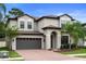 Stunning two-story home boasts a brick driveway, manicured lawn, and a two-car garage at 11006 Tahiti Isle Ln, Tampa, FL 33647