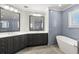 Modern bathroom featuring double vanity, luxurious soaking tub, and glass enclosed shower with blue tiled walls at 1171 Red Maple Ne Cir, St Petersburg, FL 33703